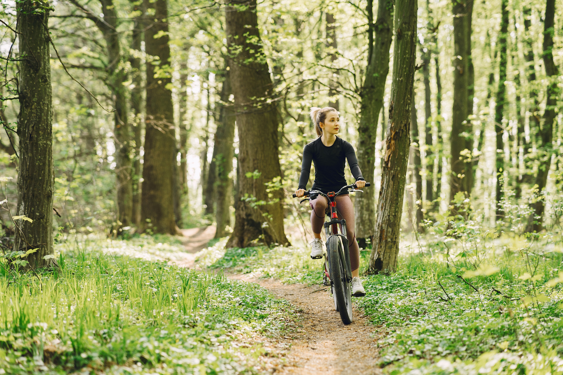 Radfahrenin auf Waldweg im nahen Umfeld der Mietwohnungsanlagr